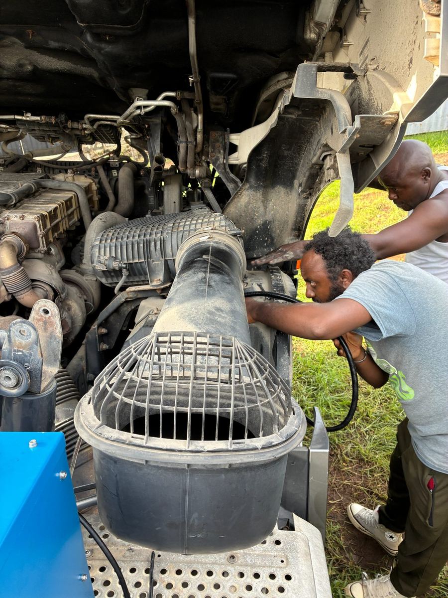 KAS technicians connecting the gas line to a truck air intake